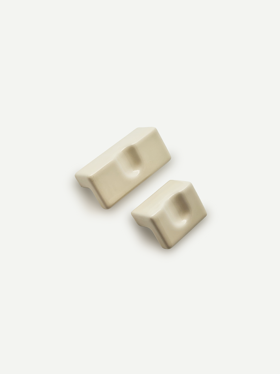 Sleek white rectangular cabinet pulls for dresser drawers.